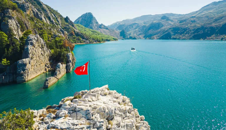 Turkish flag on a rocky point above the turquoise Green Canyon lake