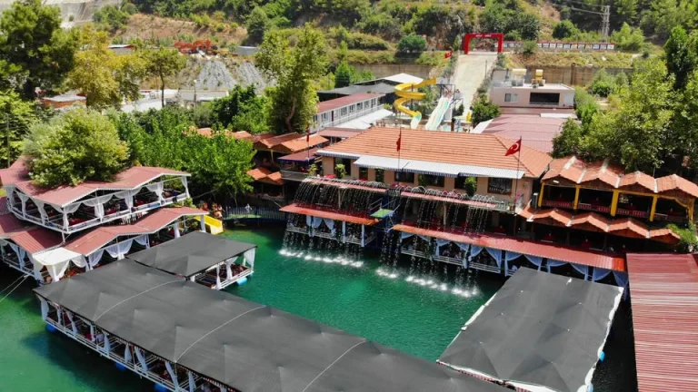 Aerial view of riverside restaurant platforms with fountains and water slides on the Dim River
